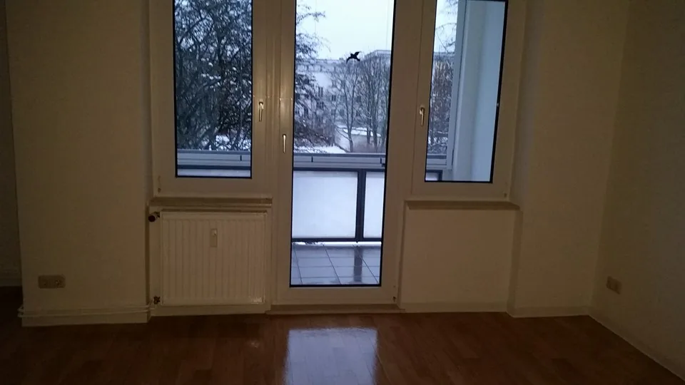 Leerer Wohnraum mit Laminat und Fenstertür nach der Endreinigung